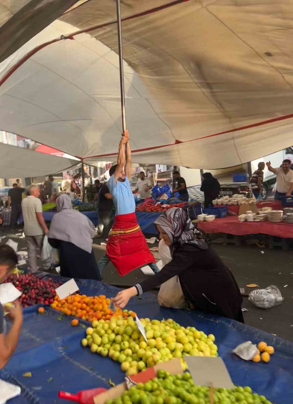 Kuvvetli rüzgarda pazarcı branda direğini bırakmadı, metrelerce havaya yükseldi
